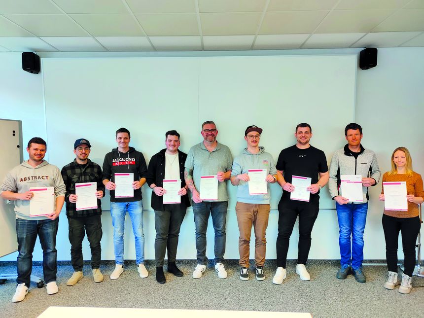 Die Kursteilnehmer können stolz sein - sie haben alle ihren Lehrabschluss nachgeholt. Gruppe von Arbeitnehmern von Liebherr, die ihren Lehrabschluss nachholten